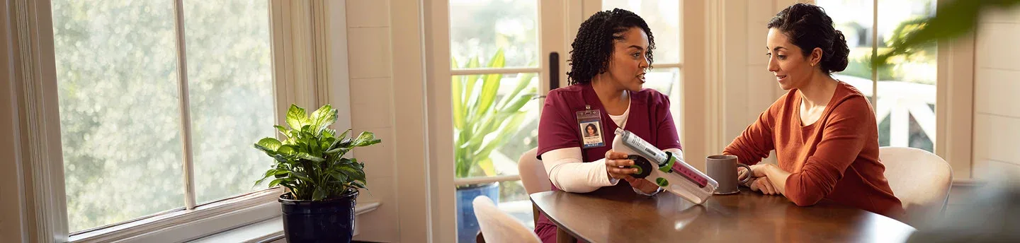 Nurse showing an infusion device to a patient