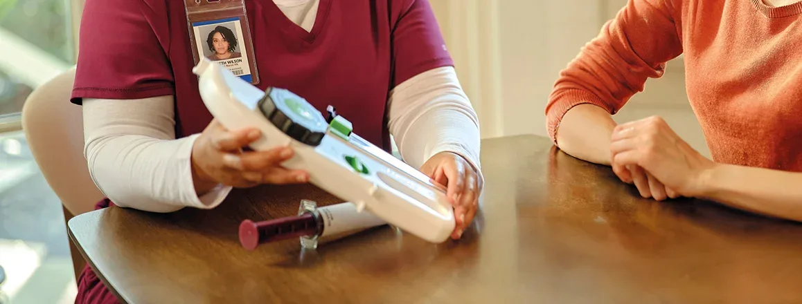 Healthcare provider showing a patient how to use a Hizentra prefilled syringe for subcutaneous Ig infusion